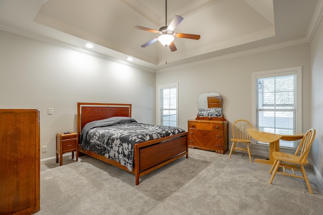 bedroom with a tray ceiling, multiple windows, ornamental molding, and ceiling fan