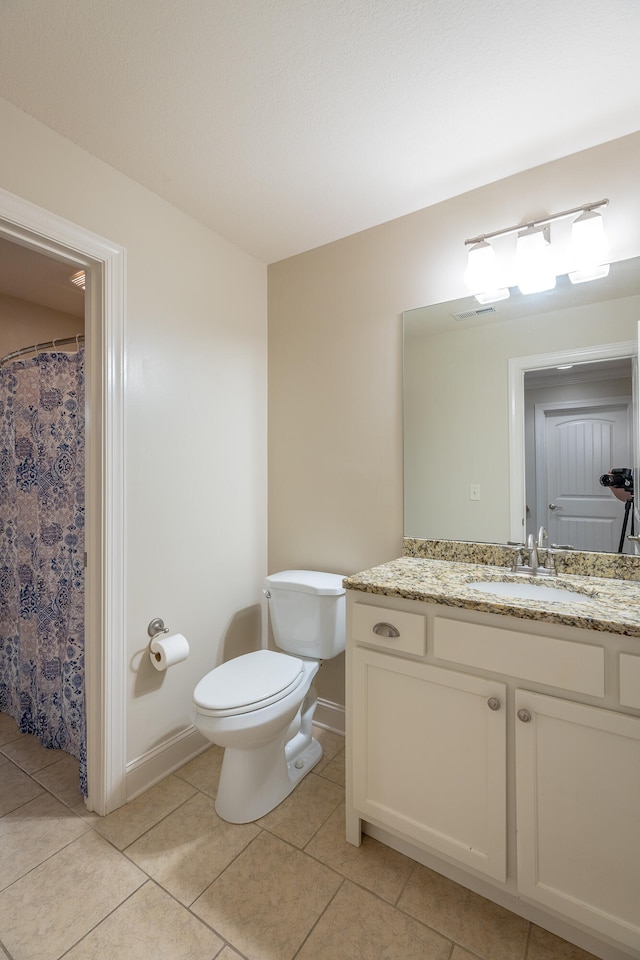 bathroom featuring tile patterned flooring, toilet, and vanity