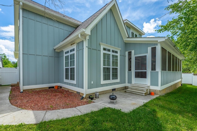 8337 Glenshire Ln, Chattanooga, TN 37421 - view of side of home featuring fence, board and batten siding, entry steps, a sunroom, and a lawn