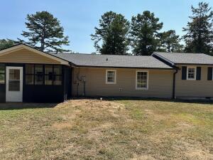 rear view of property featuring a lawn