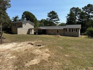 rear view of property featuring a yard