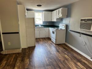 kitchen featuring dark hardwood / wood-style flooring, white electric range oven, and white cabinets