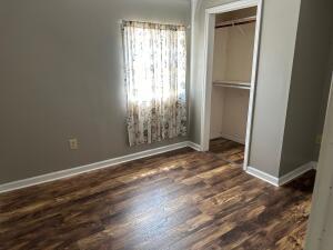 unfurnished bedroom featuring dark hardwood / wood-style floors and a closet