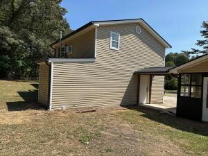 view of side of home with a yard