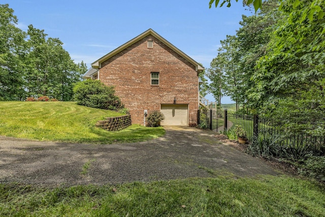 view of side of property featuring a garage and a yard