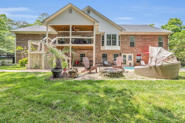 back of house with a fire pit, ceiling fan, a lawn, and a patio area