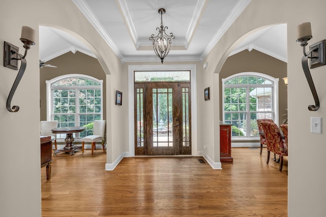 entryway featuring ceiling fan with notable chandelier, hardwood / wood-style flooring, and crown molding