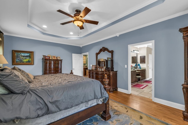 bedroom with crown molding, hardwood / wood-style floors, connected bathroom, and ceiling fan