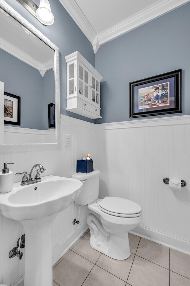 bathroom featuring ornamental molding, toilet, and tile patterned flooring