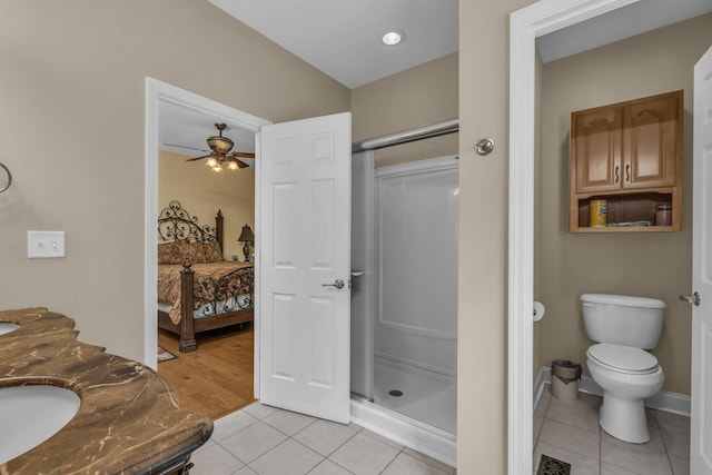 bathroom featuring toilet, tile patterned flooring, vanity, ceiling fan, and a shower with shower door