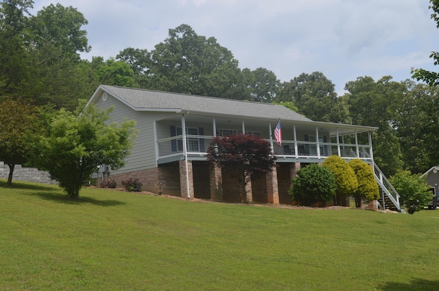 view of front of house with a balcony and a front yard