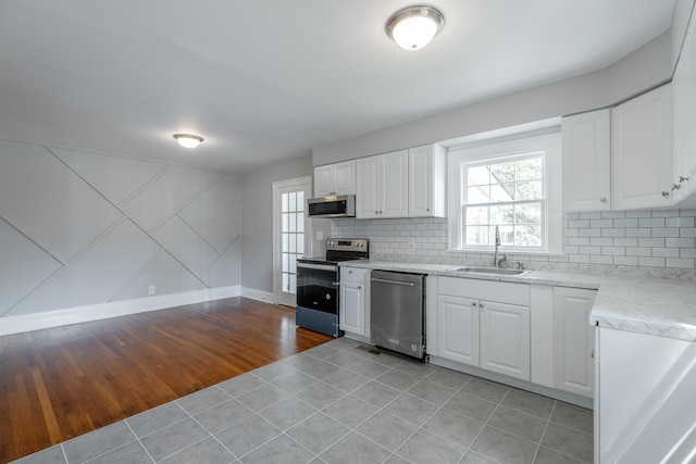 kitchen with light wood-type flooring, appliances with stainless steel finishes, a wealth of natural light, and sink