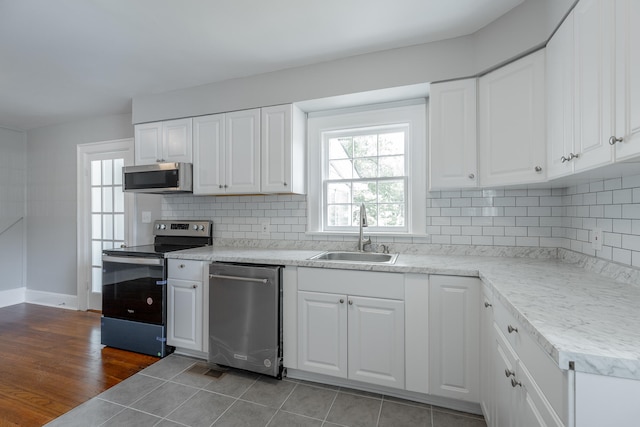 kitchen featuring a healthy amount of sunlight, wood-type flooring, sink, and appliances with stainless steel finishes