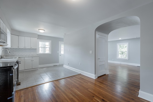 kitchen featuring a healthy amount of sunlight, white cabinets, and light hardwood / wood-style floors