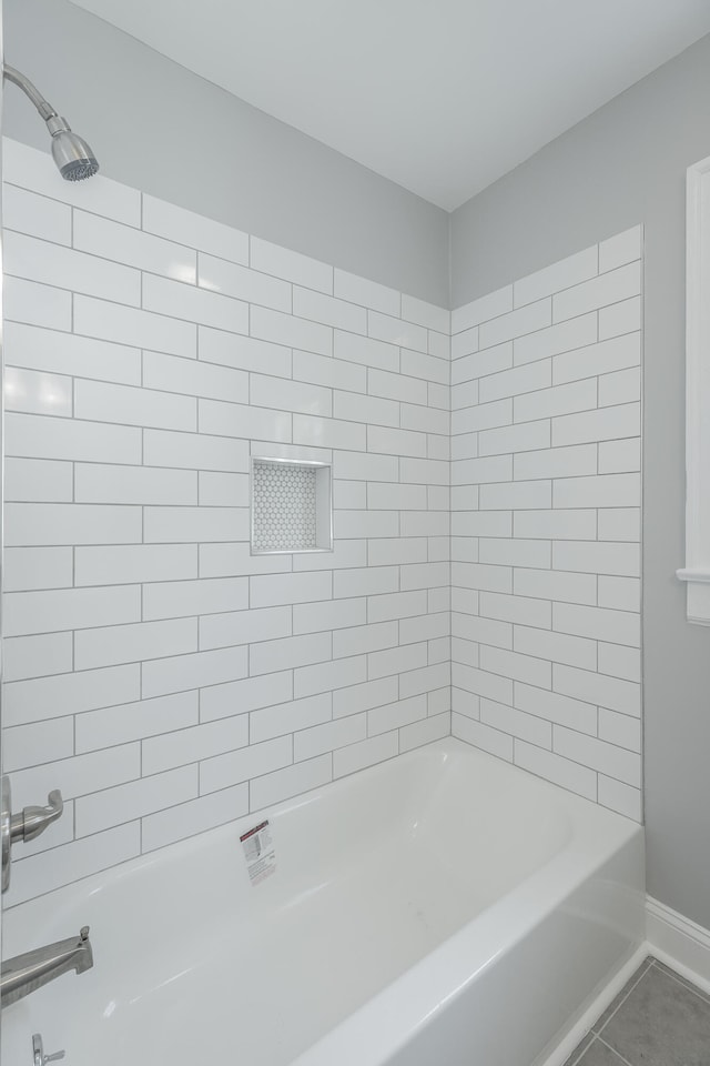 bathroom featuring tiled shower / bath combo and tile patterned floors