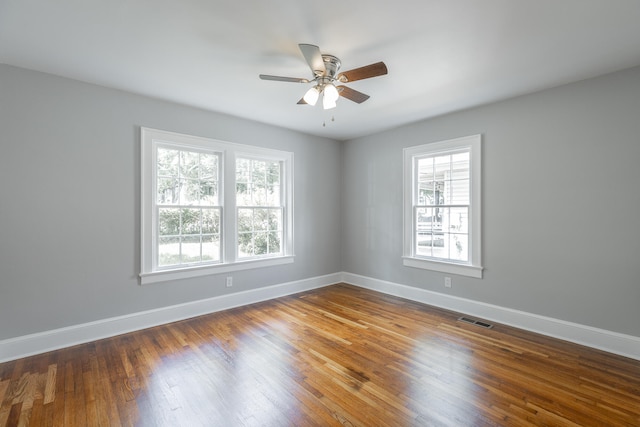 unfurnished room featuring plenty of natural light, ceiling fan, and wood-type flooring