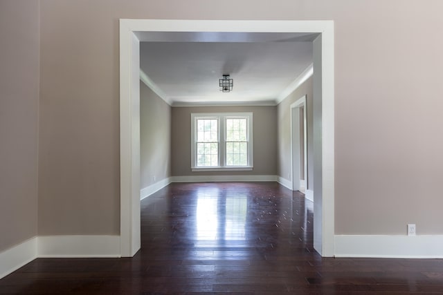 spare room featuring ornamental molding and dark wood-type flooring