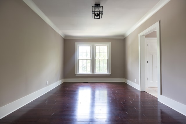 spare room featuring dark hardwood / wood-style floors and crown molding