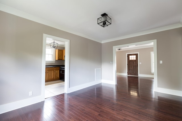 empty room with wood-type flooring and crown molding