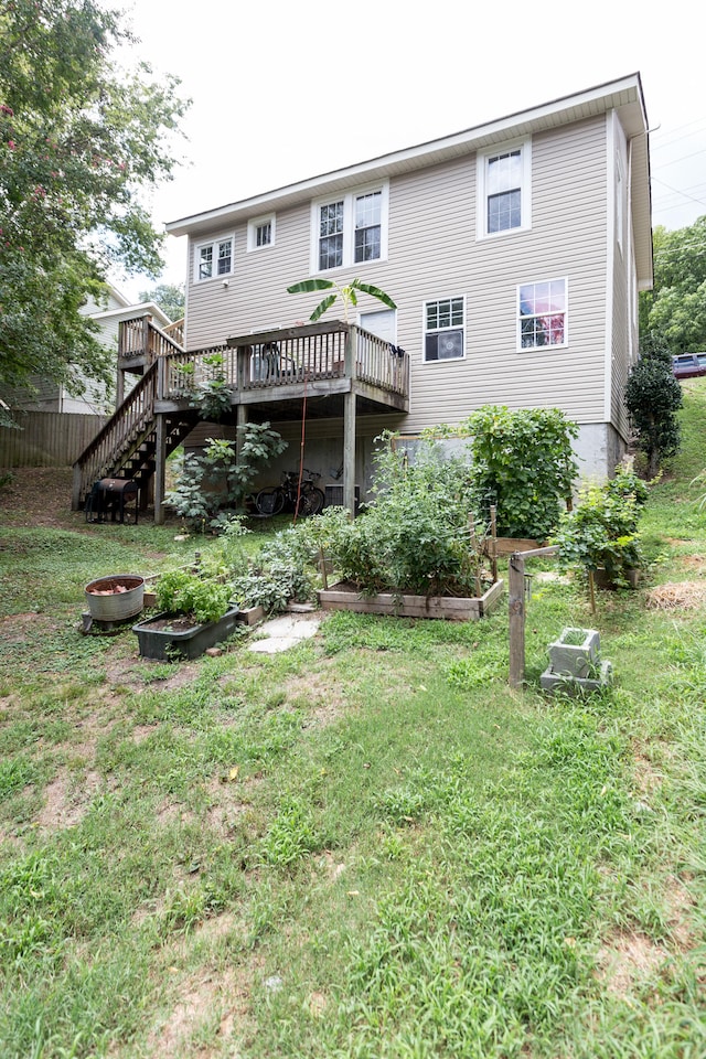 back of house featuring a lawn and a deck