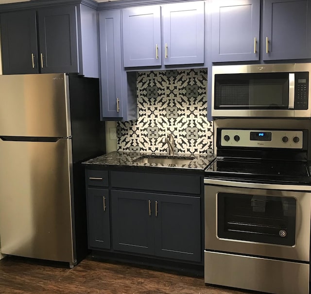 kitchen with backsplash, appliances with stainless steel finishes, dark hardwood / wood-style floors, and sink