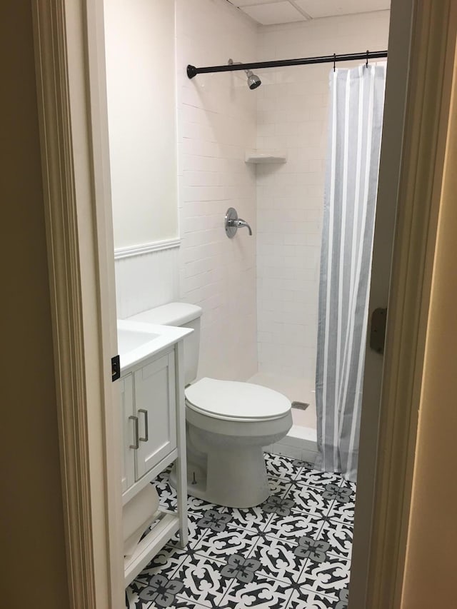 bathroom with a shower with shower curtain, tile patterned flooring, toilet, and vanity