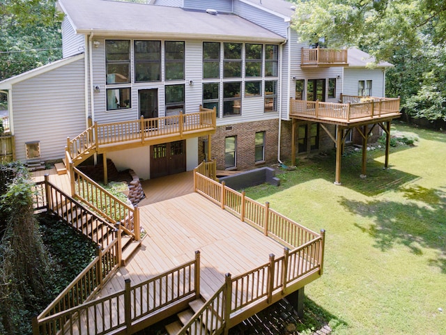 rear view of house with a deck and a yard