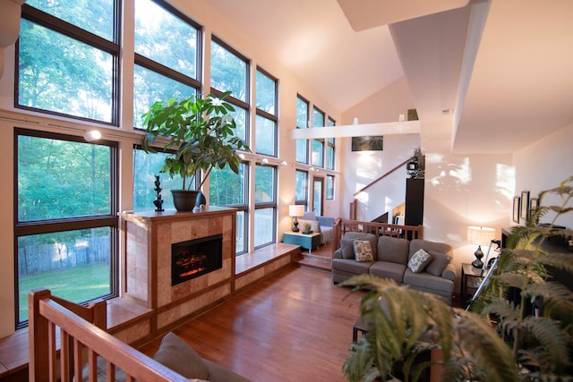 living room with a premium fireplace, wood-type flooring, and high vaulted ceiling