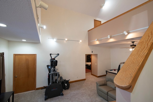 sitting room with a textured ceiling, light colored carpet, and ceiling fan