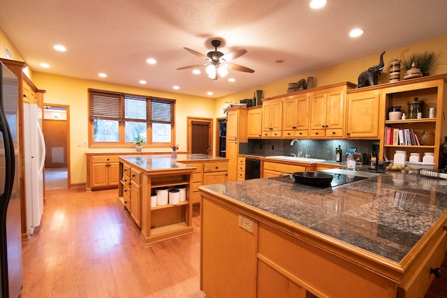 kitchen featuring tasteful backsplash, a kitchen island, light wood-type flooring, sink, and black electric cooktop