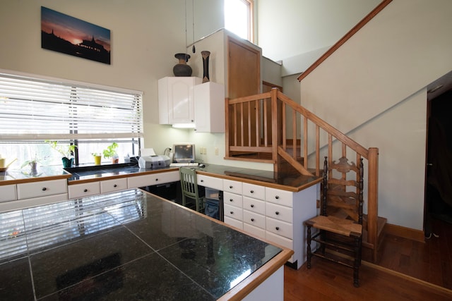 kitchen featuring a high ceiling, dark hardwood / wood-style floors, and white cabinets