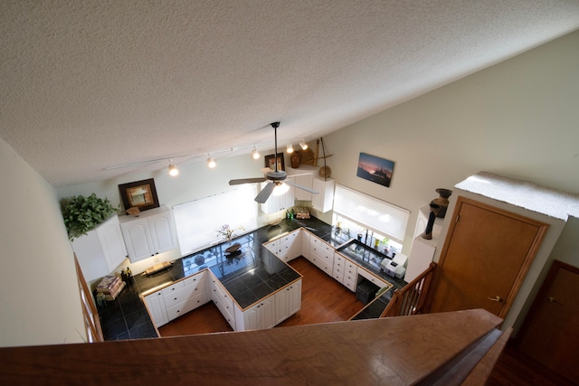 living room with dark wood-type flooring, a textured ceiling, and ceiling fan