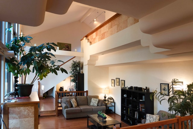 living room with hardwood / wood-style flooring, rail lighting, and vaulted ceiling