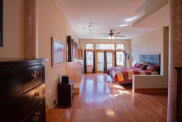 bedroom featuring a textured ceiling and light hardwood / wood-style flooring