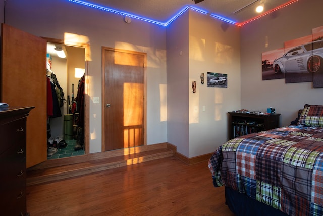 bedroom with wood-type flooring, a textured ceiling, and ornamental molding