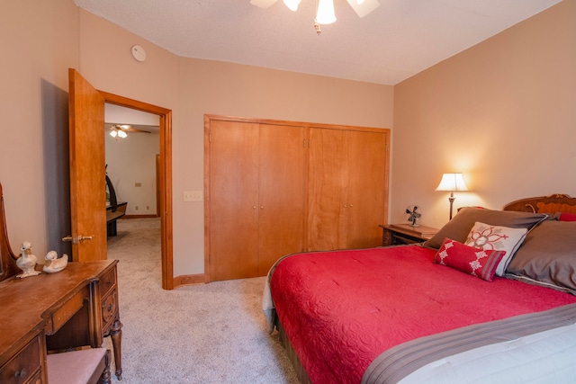 bedroom with ceiling fan, light carpet, and a closet