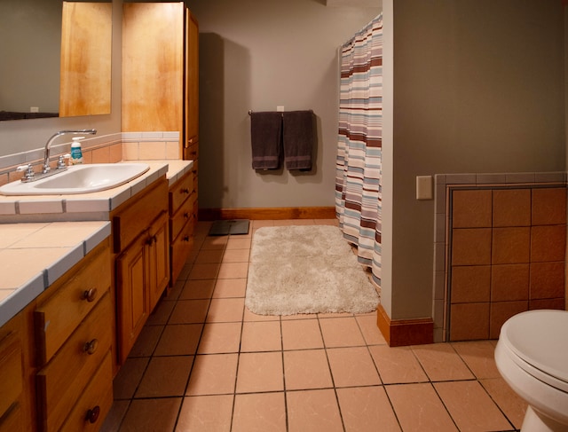 bathroom with toilet, vanity, and tile patterned floors