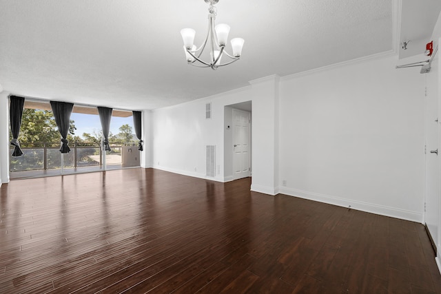 unfurnished room featuring a textured ceiling, dark hardwood / wood-style floors, an inviting chandelier, ornamental molding, and a wall of windows