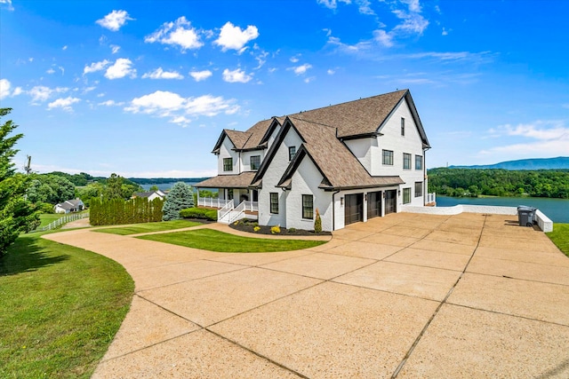 view of side of property with a yard, a garage, and a porch