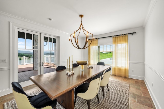 dining room featuring french doors, plenty of natural light, an inviting chandelier, and ornamental molding