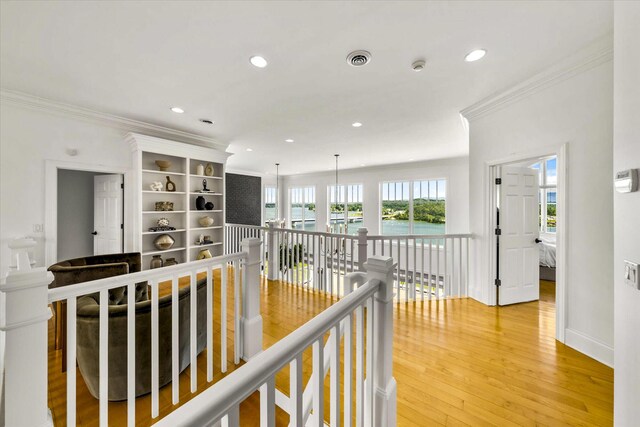 hallway featuring crown molding and light hardwood / wood-style flooring