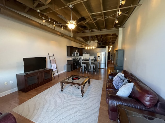 living room with dark hardwood / wood-style flooring and ceiling fan