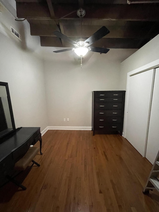 bedroom with hardwood / wood-style floors, ceiling fan, and beamed ceiling