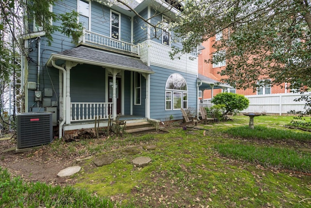 back of property featuring a balcony, central air condition unit, and covered porch