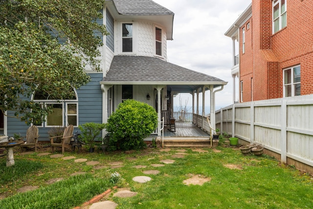 rear view of house featuring a lawn and covered porch