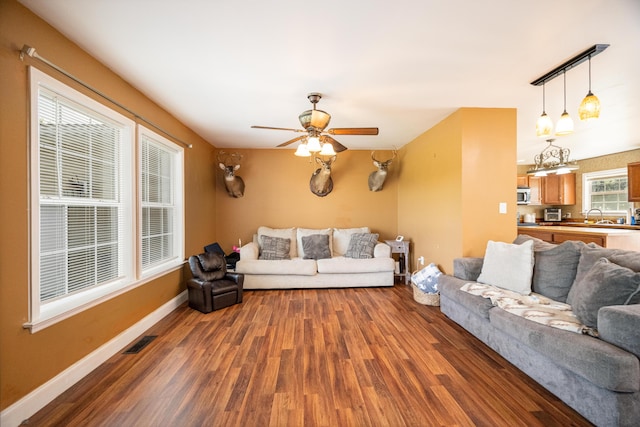 living room with ceiling fan, dark hardwood / wood-style floors, and sink