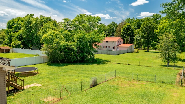 view of yard with a trampoline and a rural view