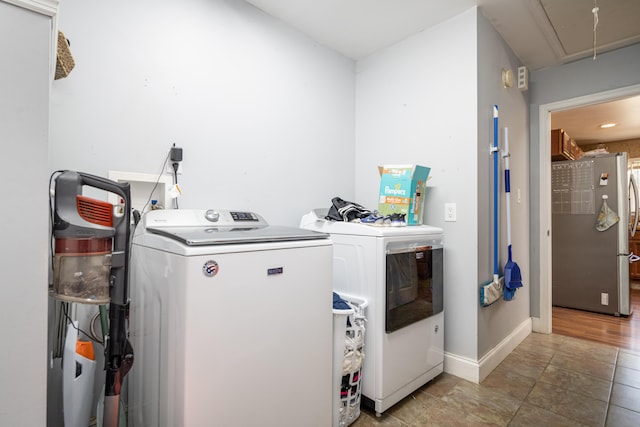 clothes washing area with washing machine and dryer and hardwood / wood-style floors