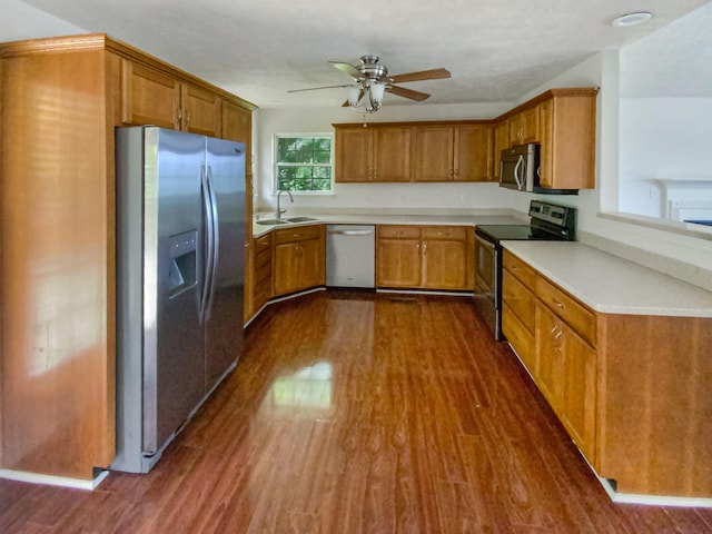 kitchen with appliances with stainless steel finishes, ceiling fan, dark hardwood / wood-style flooring, and sink