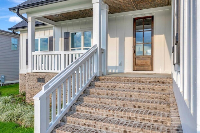 view of exterior entry featuring a porch, board and batten siding, and a shingled roof